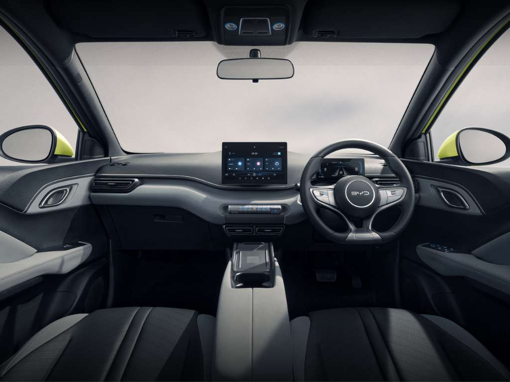 Interior depan BYD Atto1 dengan setir multifungsi, layar sentuh besar, dan tata letak modern bergaya minimalis.